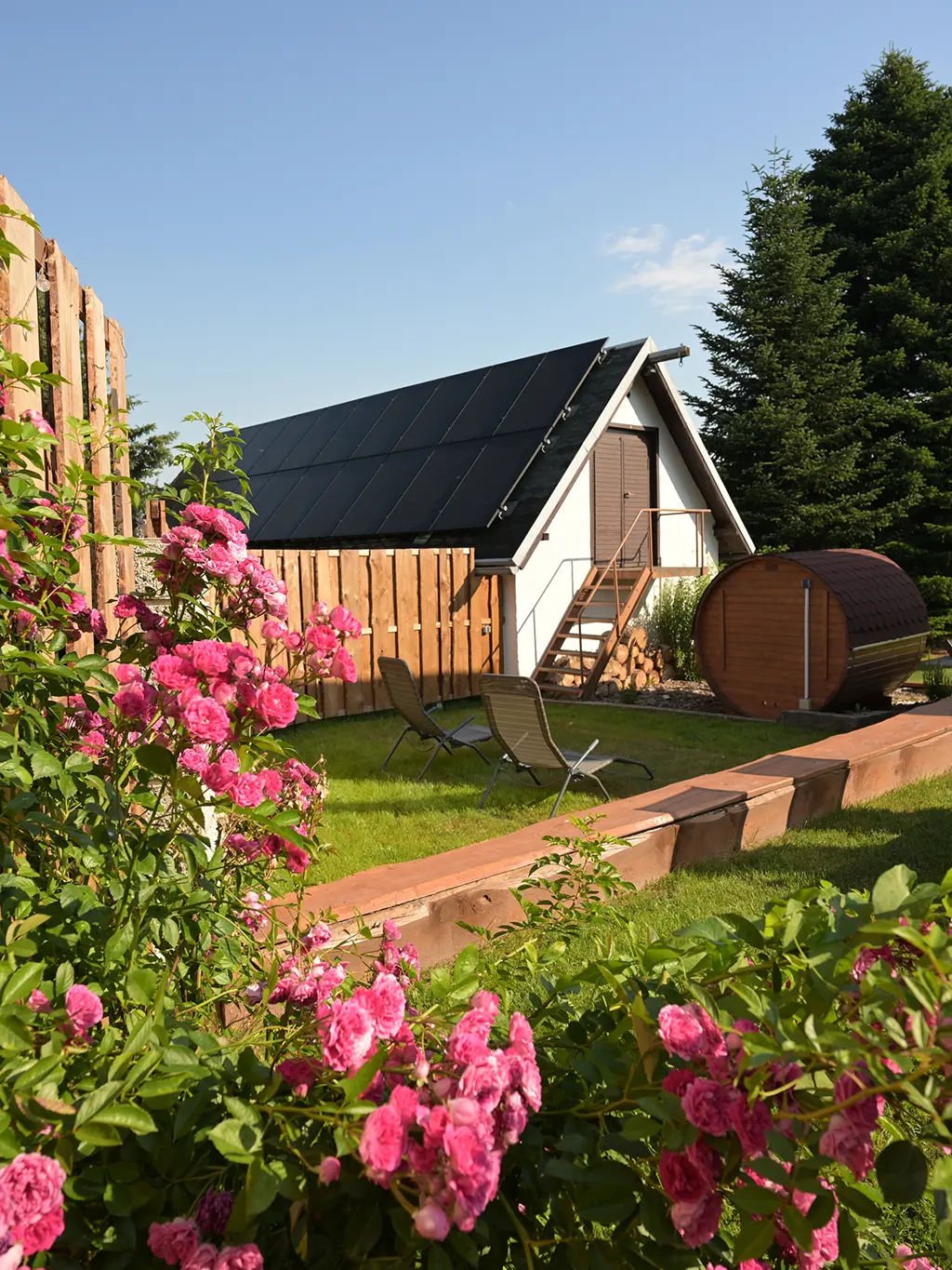 Garten mit Campinghütte und blühenden Sträuchern bei Zittau