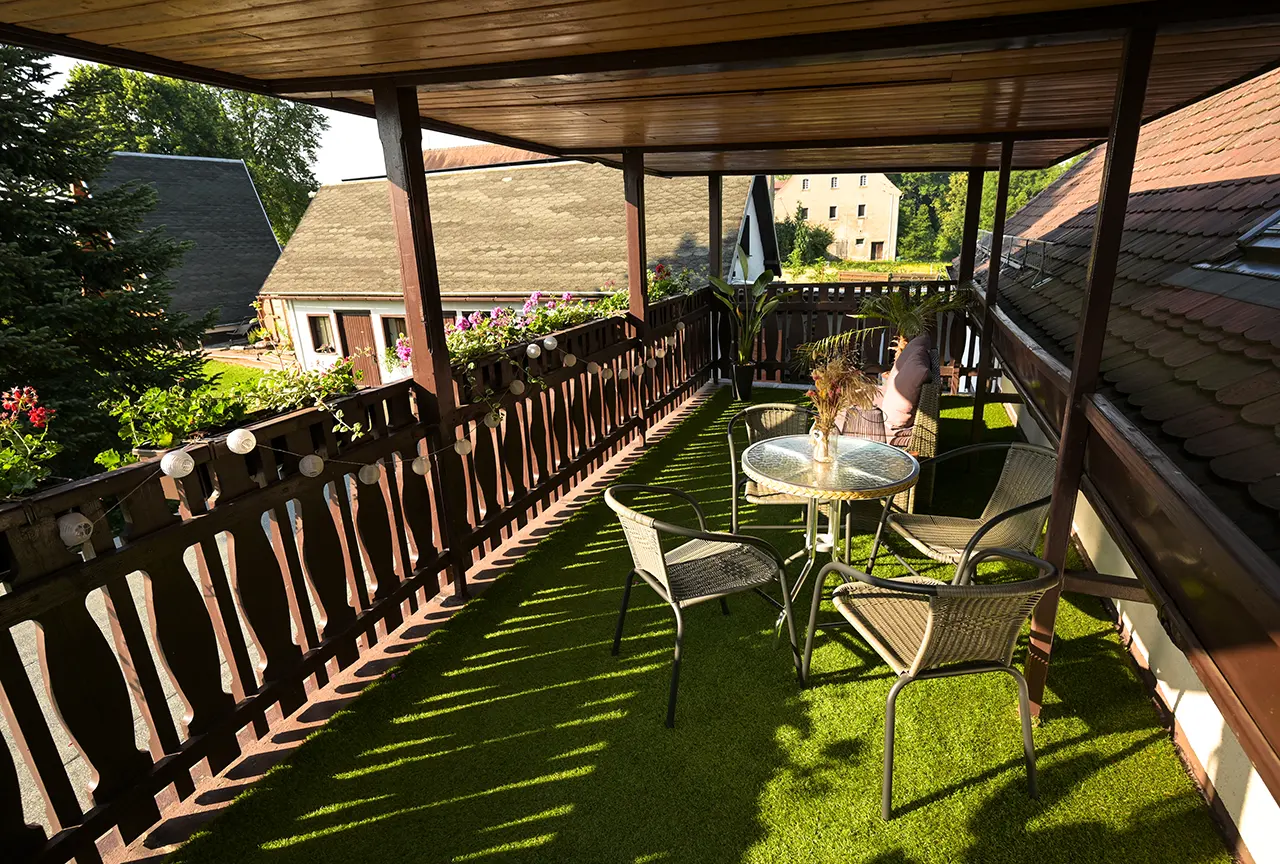 Überdachte Dachterrasse mit Holzboden und Sitzmöbeln der Ferienwohnung Frieda