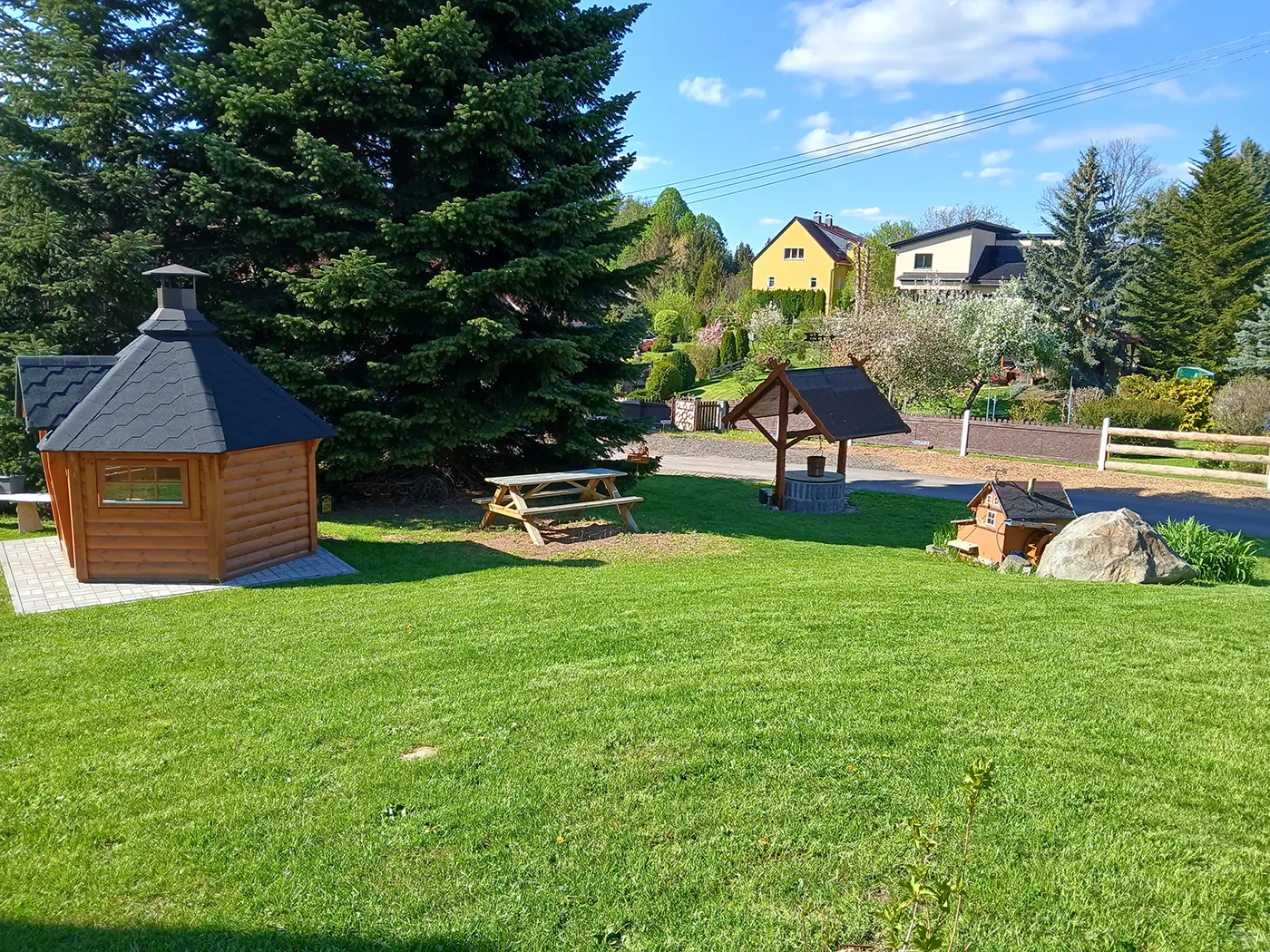 Gartenwiese mit Campinghütten und Bäumen bei Zittau